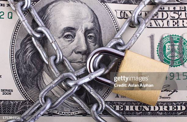 padlock on hundred dollar bill - slot beveiligingsapparatuur stockfoto's en -beelden