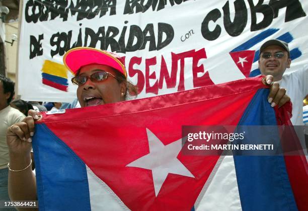 Una mujer con una bandera cubana grita consignas a favor de Cuba durante una marcha por el dia de los trabajadores en Quito, el 01 de mayo de 2004....