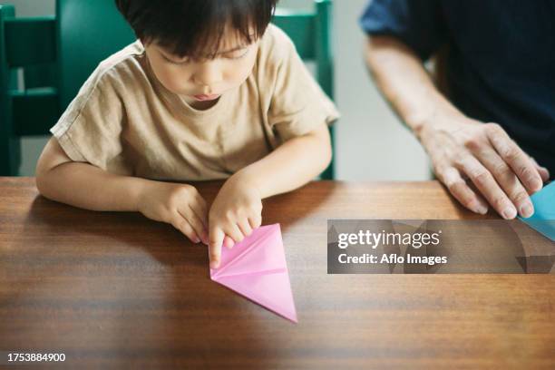 japanese kid playing with his dad at home - origami asia stock pictures, royalty-free photos & images