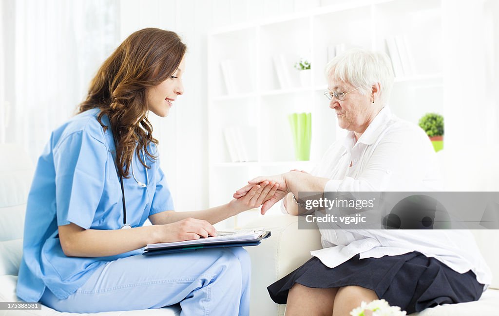 Doctor revisando la Psoriasis en mano de mujer Senior paciente.
