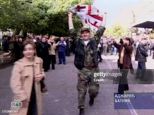 THIS Russian NTV channel TV grab shows a local militiaman joints the supporters of the Georgian President Mikhail Saakashvili during a demonstration...