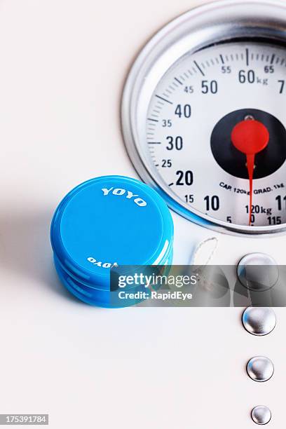 yo-yo with scale: on and off dieting does not work - yoyo dieting stock pictures, royalty-free photos & images