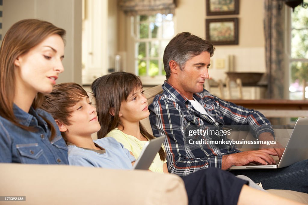 Crianças ver televisão enquanto os pais Usar Portátil