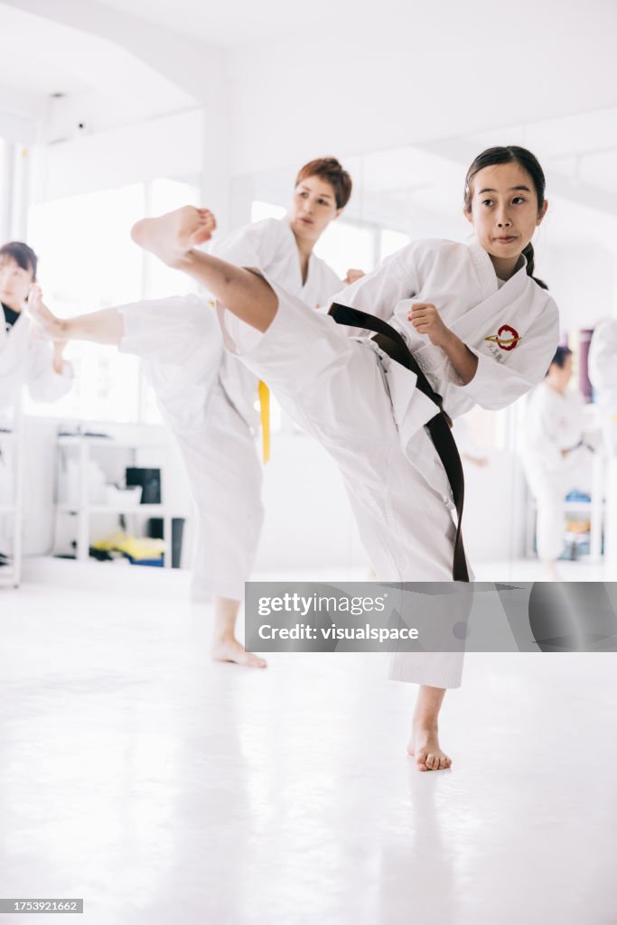 空手の蹴りを練習する若い日本の女の子