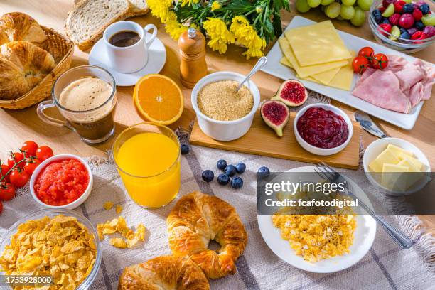 healthy breakfast served with scrambled eggs, coffee, juice, croissants and fruits - snack background stock pictures, royalty-free photos & images