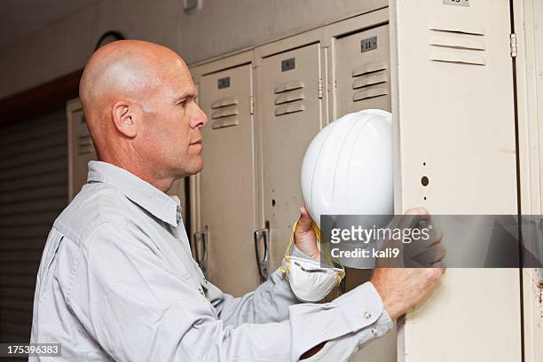 worker taking hardhat out of locker - sports equipment locker stock pictures, royalty-free photos & images