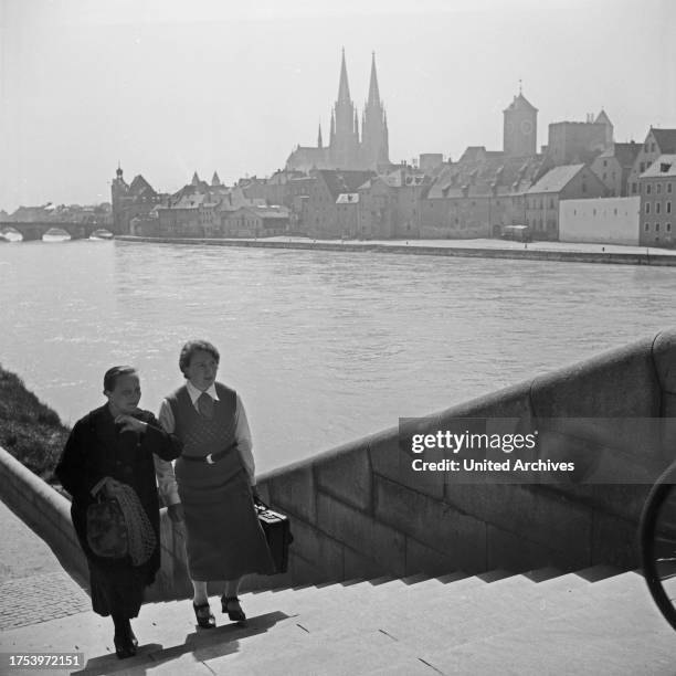 Two women on the stairs to one of the bridges over river Danube at Regensburg, Germany 1930s.