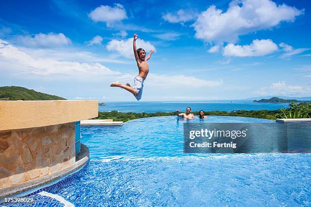 boy jumping into a swimming pool in costa rica - kid jumping into swimming pool stock pictures, royalty-free photos & images