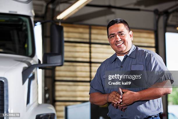 hispanic mechanic in garage with truck - mechanic uniform stock pictures, royalty-free photos & images