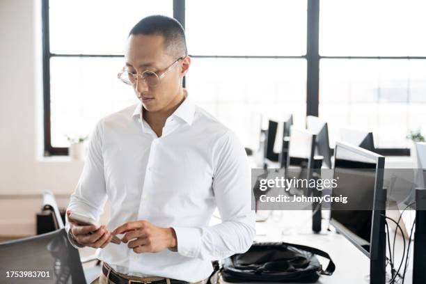 young asian business professional using smart phone - white shirt stockfoto's en -beelden