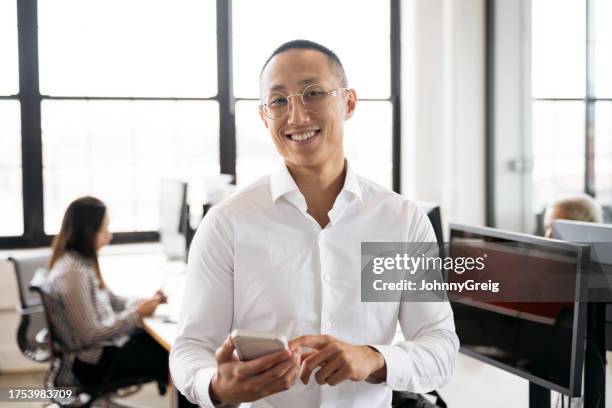 candid portrait of young businessman with portable device - open collar stock pictures, royalty-free photos & images