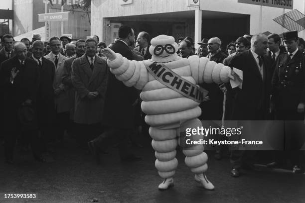 Le ministre de l'agriculture Edgard Pisani avec un Bibendum Michelin lors du salon à la Porte de Versailles à Paris le 9 mars 1964