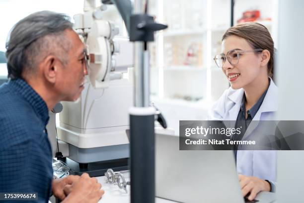 assesment of visual function an eye refraction test. a female opthamologist uses a manual phoroptor to measure the refractive error and determine the eyeglass numbers of senior male patient in an ophthalmology clinic. - eye scan stock pictures, royalty-free photos & images