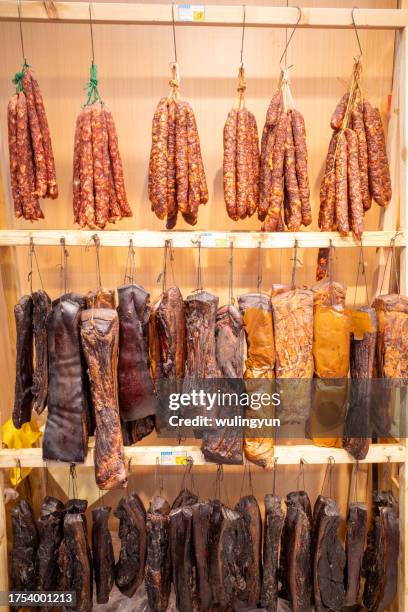 hanging xiangxi cured pork and sausages for sale - lebensmittel trocknen stock-fotos und bilder