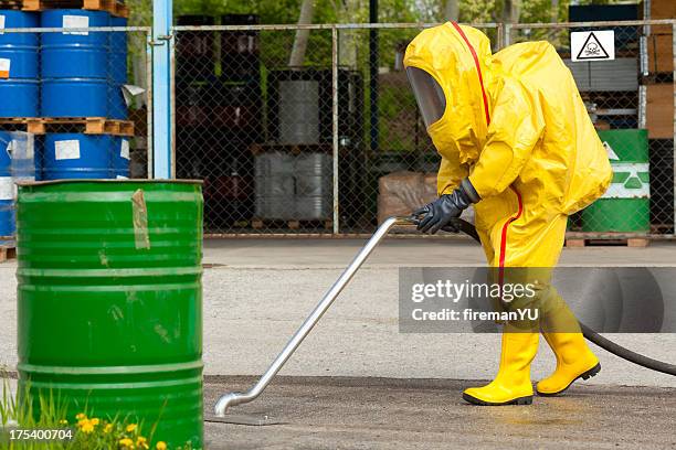 trabalhador em macacão de hazmat campo de limpeza amarelo - arma bioquímica imagens e fotografias de stock