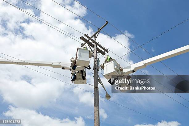 electric utility workers in truck buckets near pole - cherry picker stock pictures, royalty-free photos & images