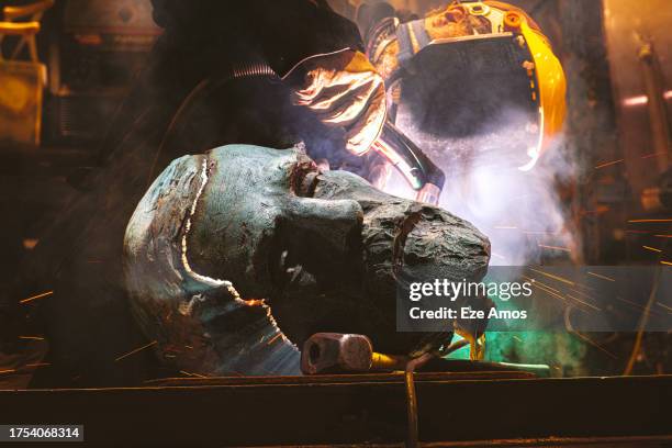 Worker using a plasma torch cuts the head of a bronze monument to Civil War General Robert E. Lee that formerly stood in Charlottesville, Virginia...