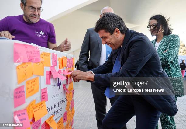 The president of the Generalitat Valenciana, Carlos Mazon , puts a note on a mural during the celebration of United Nations Day, at the City of Arts...