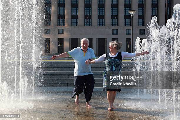 mature couple dance in fountains - fountain stock pictures, royalty-free photos & images