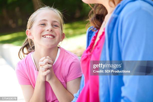 young girl pleading with her mother for something - pleading stock pictures, royalty-free photos & images