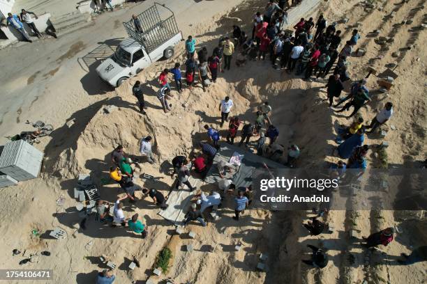 An aerial view of bodies of a Palestinian family, killed during the Israeli attacks, being buried in a mass grave since some cemeteries run out of...