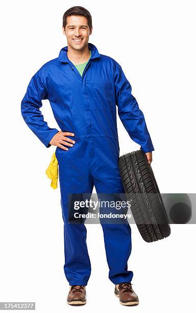 automotive technician holding a spare tyre - isolated - white jumpsuit stock pictures, royalty-free photos & images
