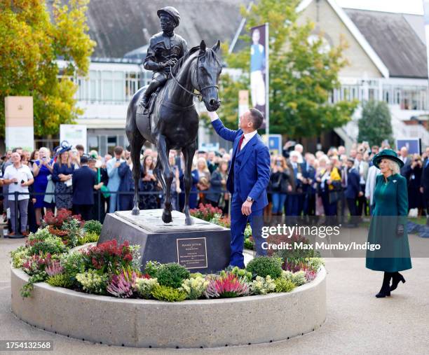 Queen Camilla looks on as Frankie Dettori stands next to a newly unveiled statue of himself as they attend QIPCO British Champions Day at Ascot...