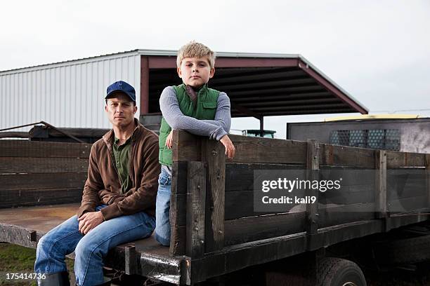 farmer and son sitting on back of truck - garden shed stock pictures, royalty-free photos & images