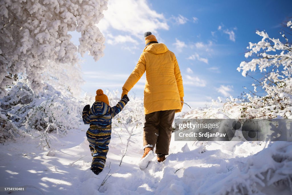 Mom and son enjoying a carefree winter day on the snowy mountain
