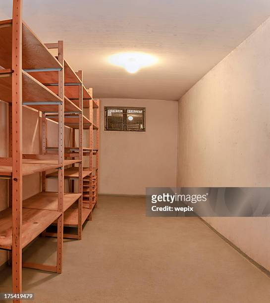 empty basement room wooden storage shelve illuminated ceiling lamp - basement stock pictures, royalty-free photos & images