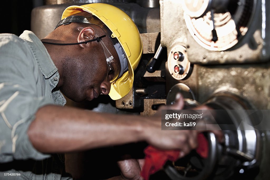 African American Arbeitnehmer mit drill Drücken