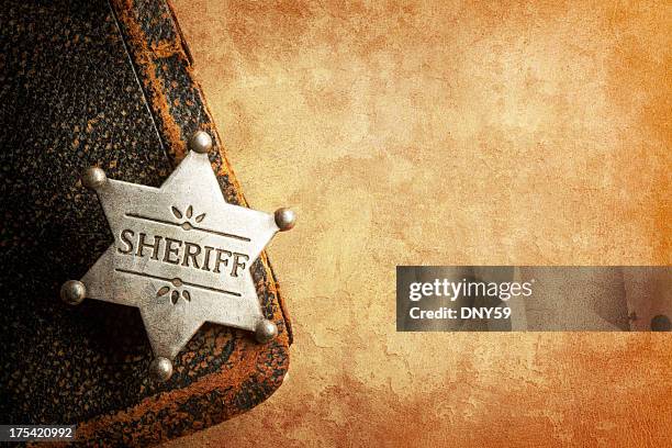 sheriff's badge on warm textured surface - police badge stock pictures, royalty-free photos & images