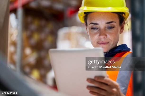 female storage packer checking inventory on digital tablet - reflective clothing stock pictures, royalty-free photos & images