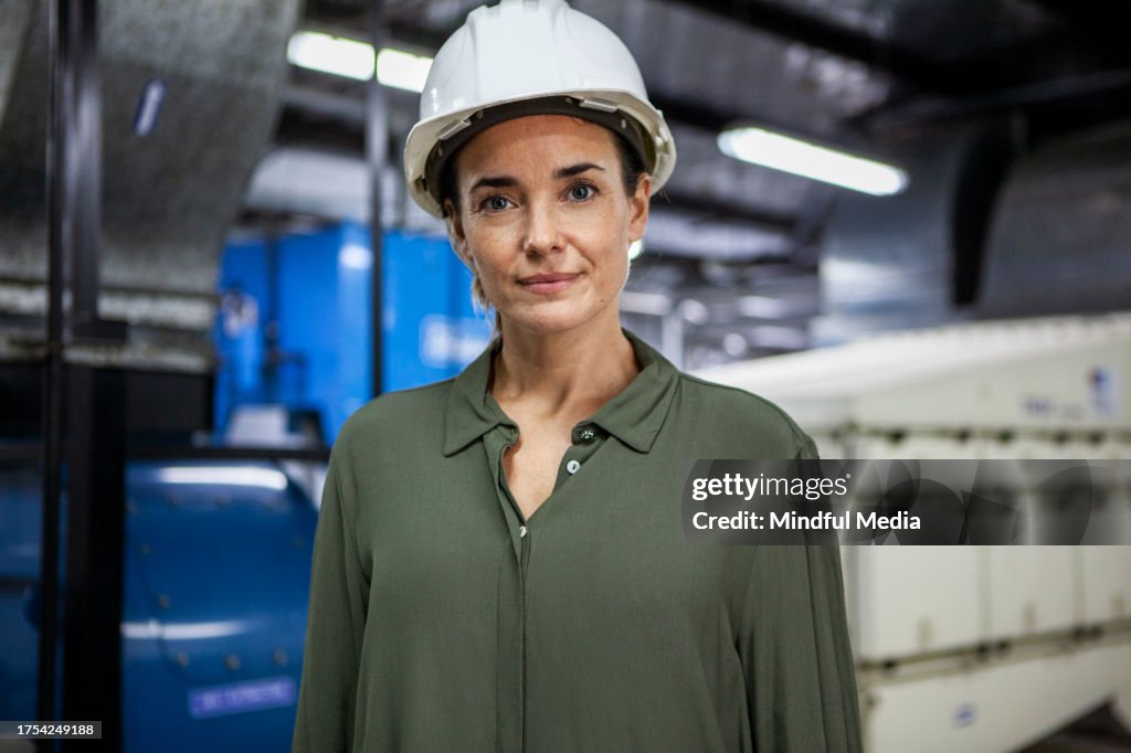 Female warehouse supervisor standing inside industrial facility