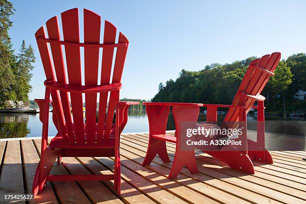 muskoka chairs on a sunny morning - adirondack chair stockfoto's en -beelden