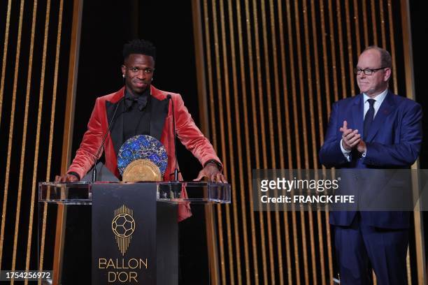 Real Madrid's Brazilian forward Vinicius Junior reacts as he receives the Socrates Trophy for most involved player in societal and charitable...