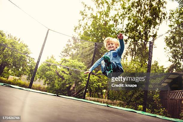 junge springen auf trampolin - trampoline stock-fotos und bilder