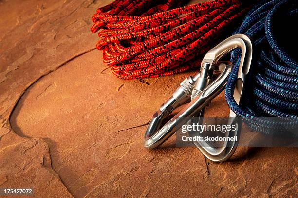 carabiner clip and climbing rope on red rock - karabijnhaak stockfoto's en -beelden
