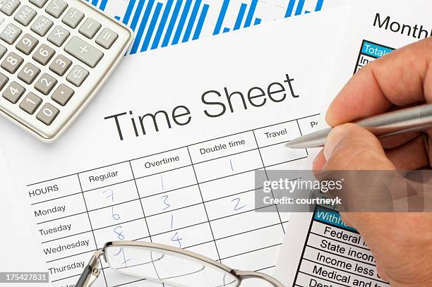 filled out time sheet with writing hand - prikkaart stockfoto's en -beelden