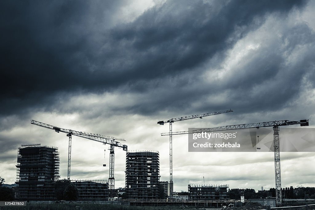 Construction Site with Cranes and Cloudy Sky