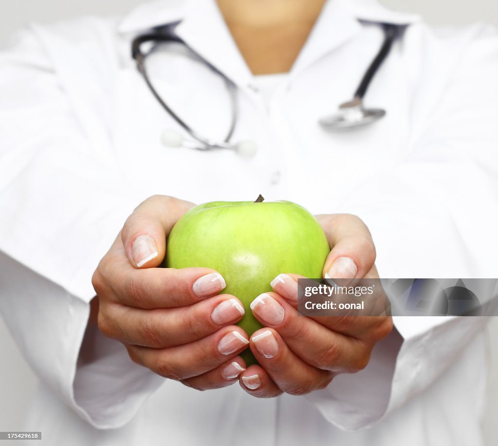 Doctor holds green apple