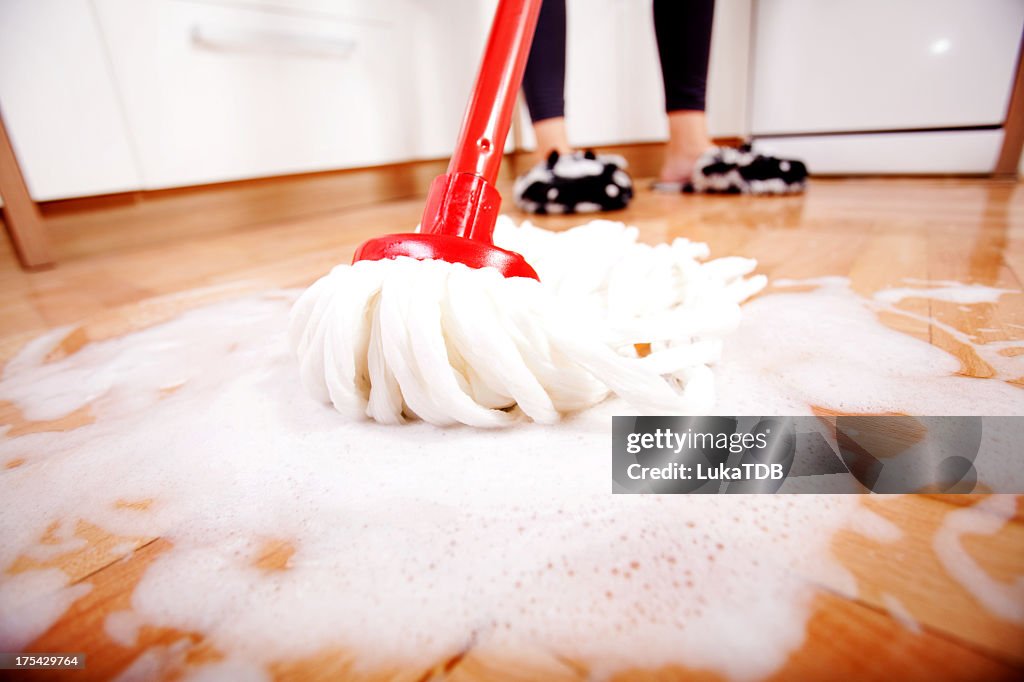 Mujer mopping un piso de madera