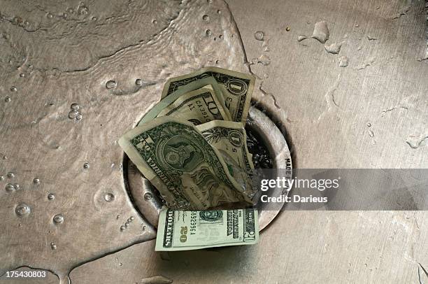 us paper currency, shoved in to the drain of a wet sink - money down the drain stock pictures, royalty-free photos & images