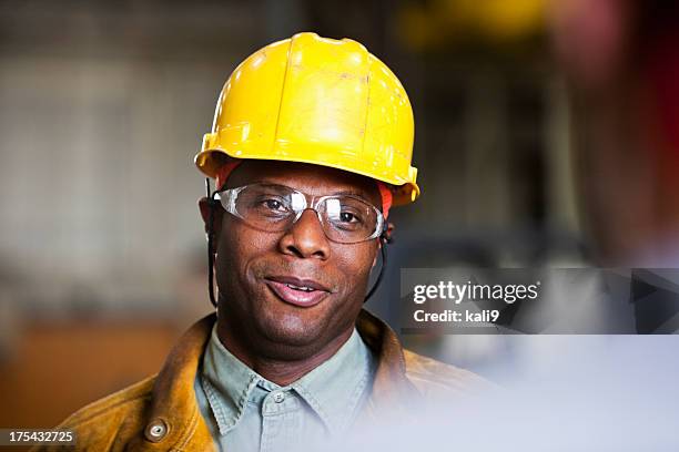 afro-americana trabalhador conversando com colegas de trabalho - capacete de trabalho - fotografias e filmes do acervo