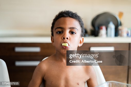 A child eating a piece of melon