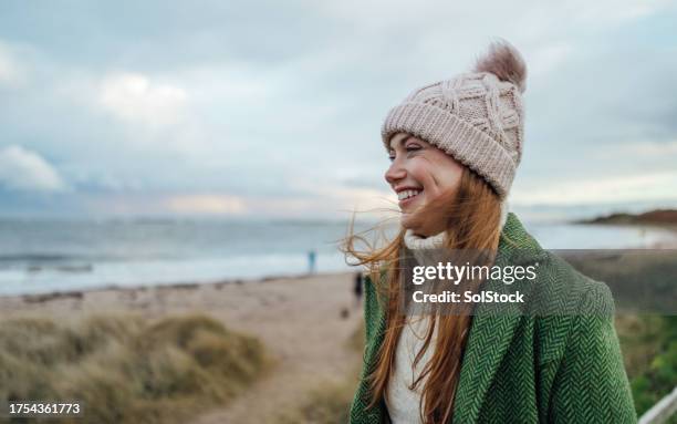 feeling happy at the beach - woman walking side view stock pictures, royalty-free photos & images