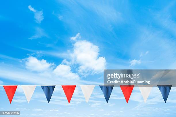 a line of british bunting hanging in the blue sky - bunting stockfoto's en -beelden