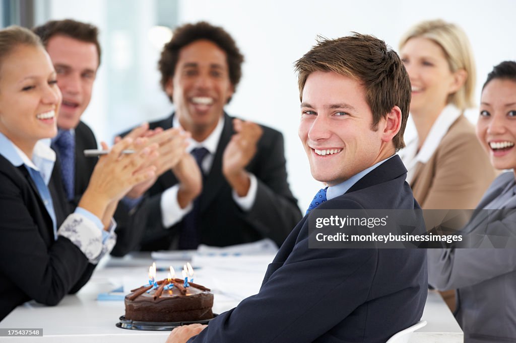 Portrait Of Male Executive Celebrating Birthday In OfficeWith Co