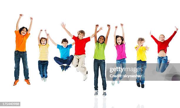 cheerful kids jumping with arms up. - jumping bildbanksfoton och bilder