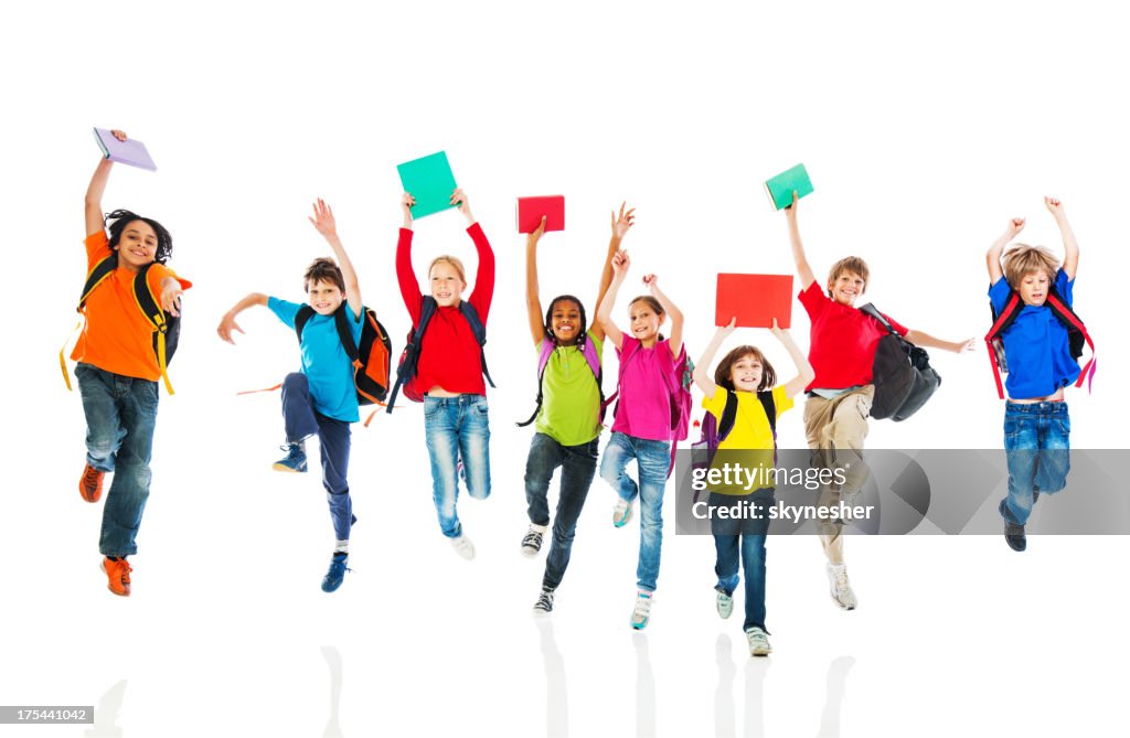 School children with backpacks and books jumping.